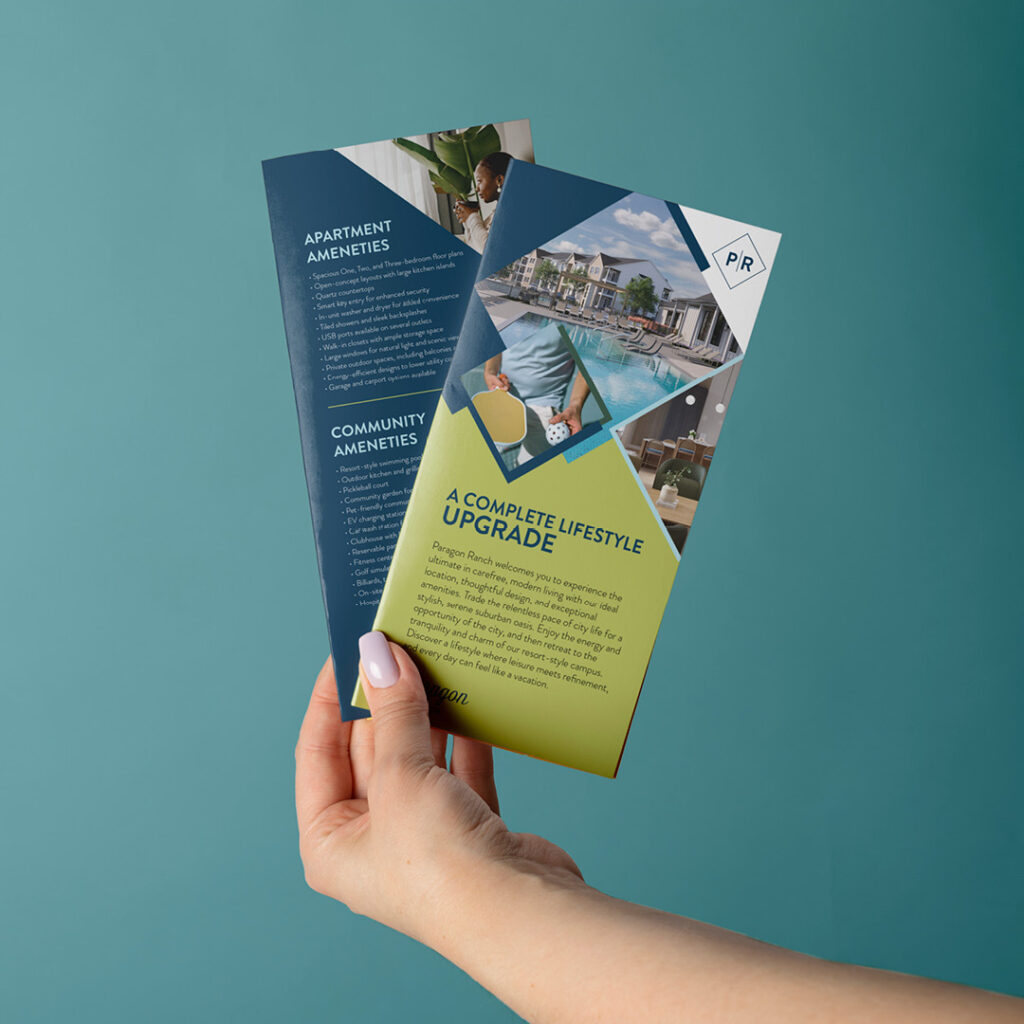 Print Marketing Collateral Design for Multifamily Branding Campaigns Hand holding colorful printed apartment marketing brochures featuring Paragon Ranch community amenities and floor plans